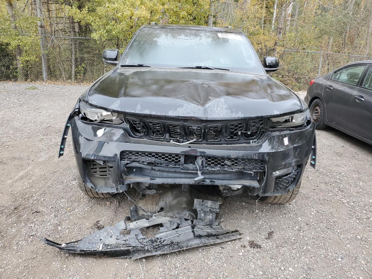 A black Jeep Grand Cherokee with severe front-end collision damage